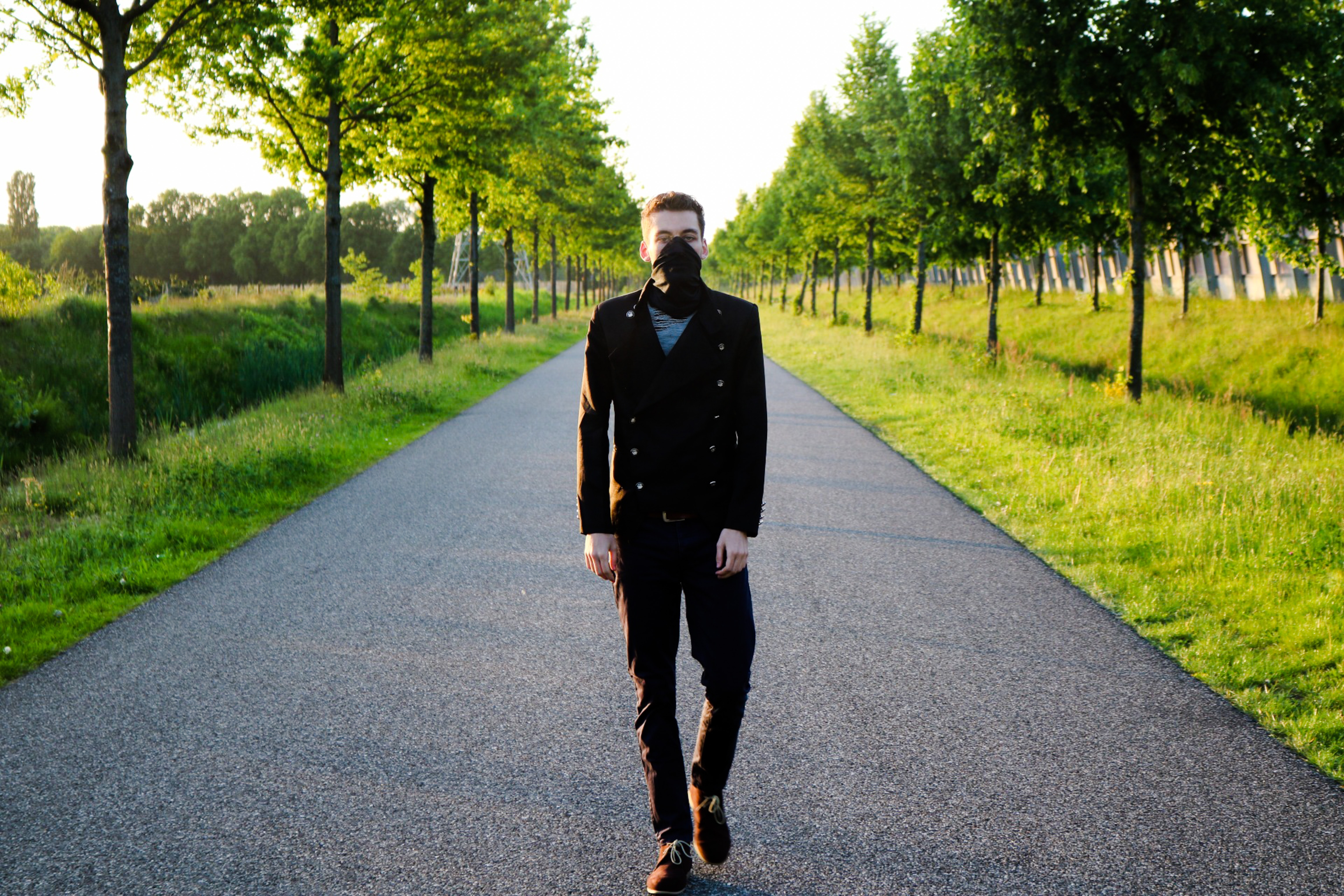 masked man walking down street