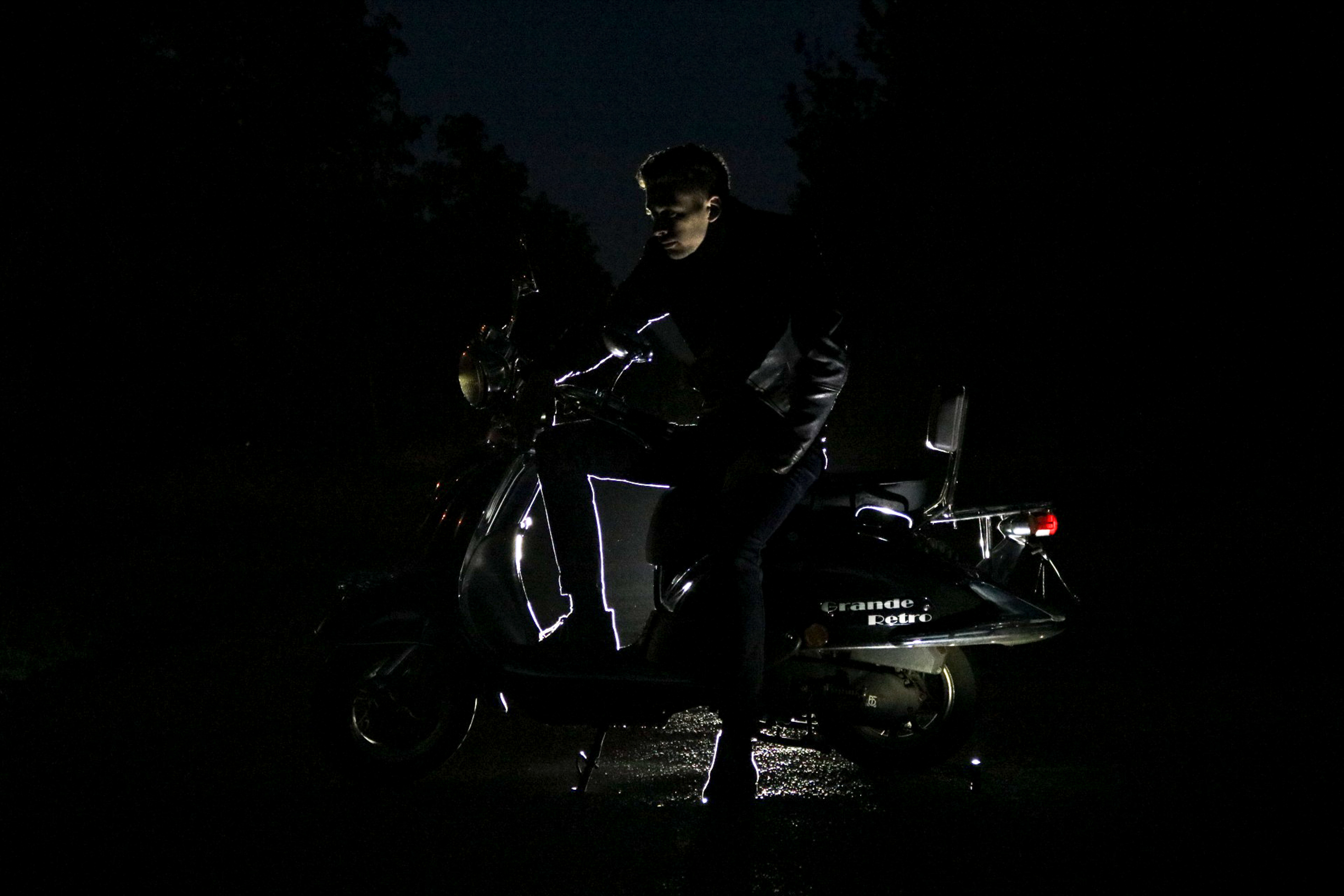 man sitting on motorcycle at night